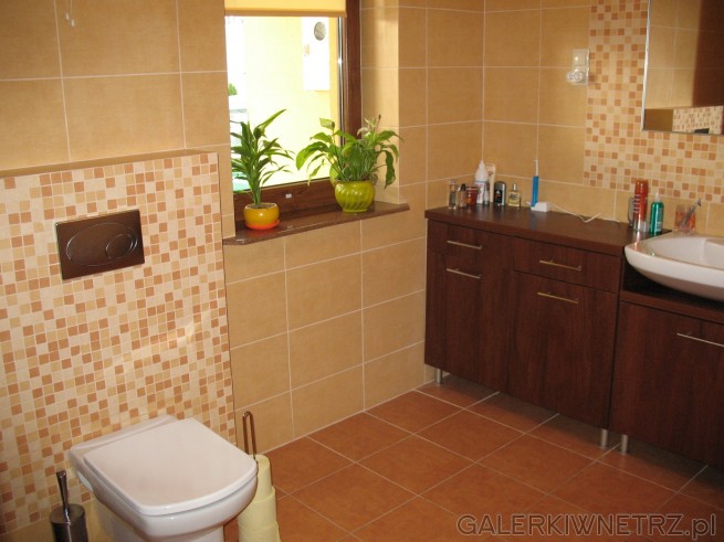 Łazienka z oknem, beżowe kafle, podwieszany WC