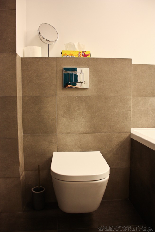 Aranżacja łazienki w spokojnych kolorach, z wiszącą misą WC o okrągłych kształtach. ...