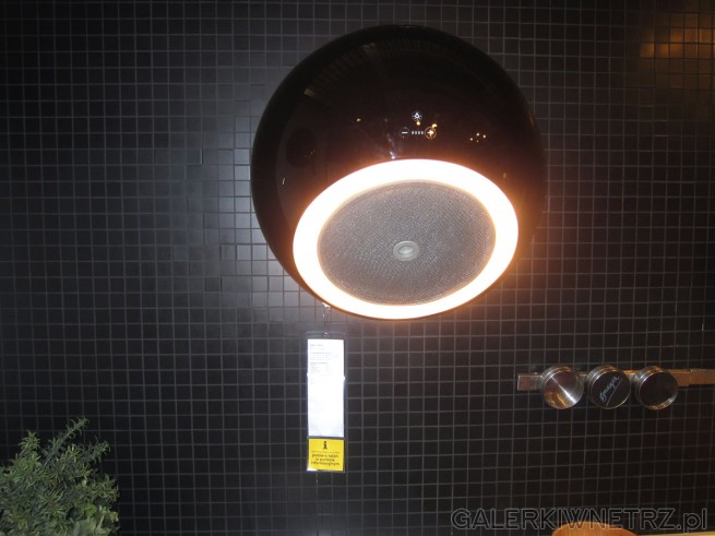 Niezwykły okap kuchenny przytwierdzony do ściany, pełni także funkcję oświetlenia. ...